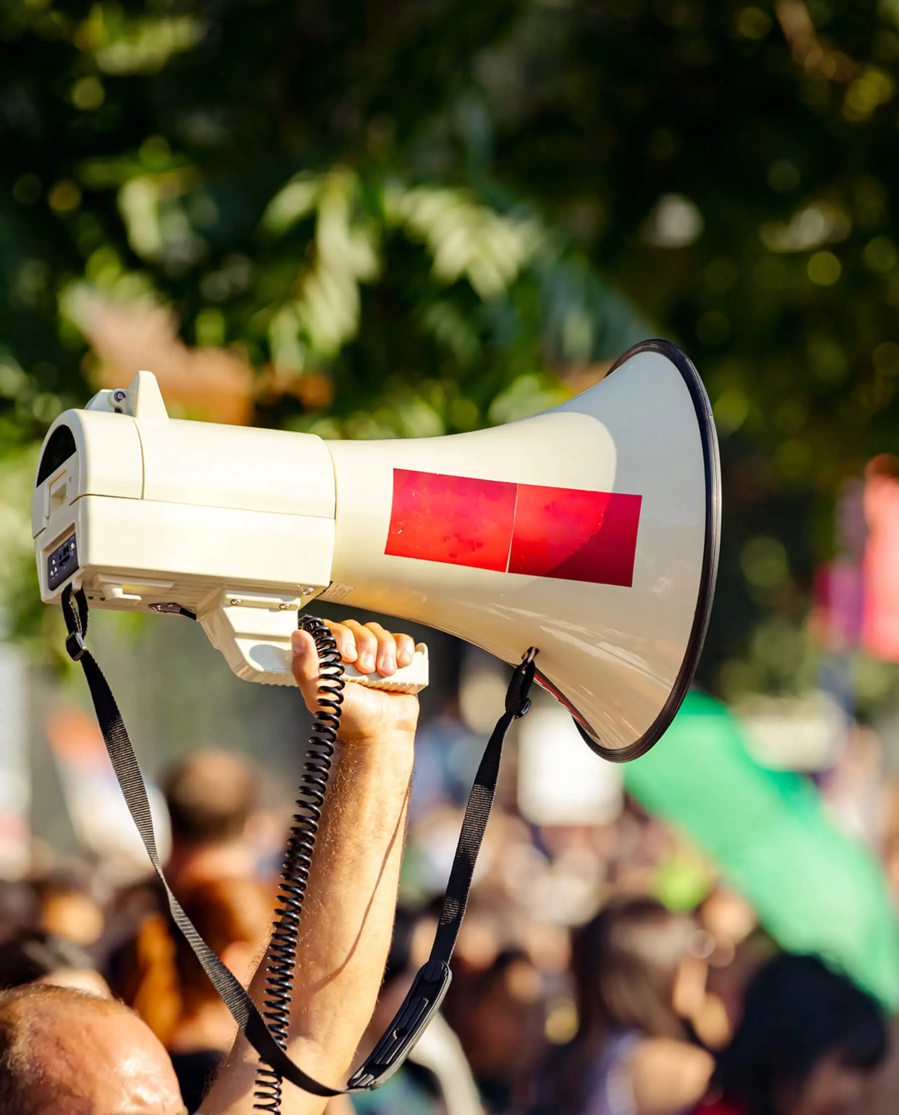 Hand raising a megaphone in crowd